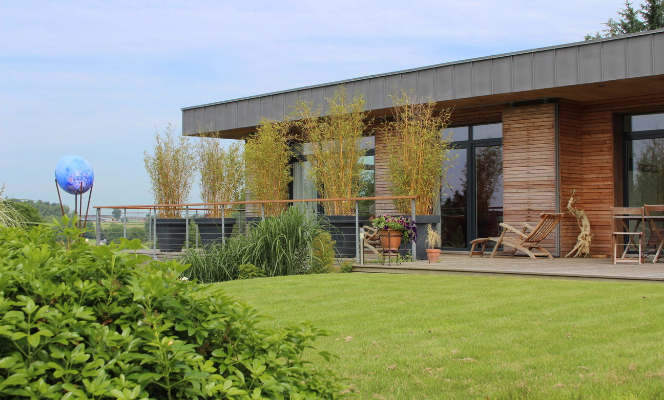 Maison moderne avec terrasse et pelouse au premier plan