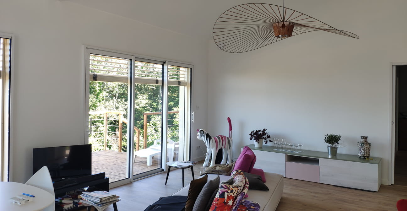 intérieur d'un salon avec une baie vitrée équipée d'une persienne électrique extérieure